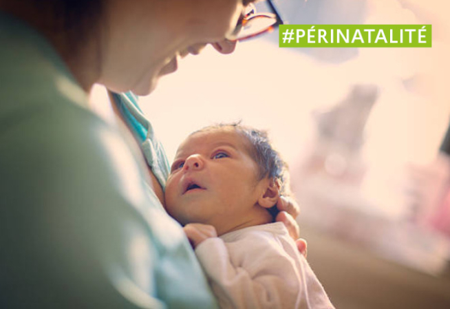 photo d'un nourrisson dans les bras de sa maman à la maternité